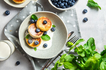 Cottage cheese pancakes with cream sauce and blueberries. syrniki 