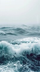Obraz premium Building ocean waves crash, creating mesmerizing sea foam on dark sea. Powerful crashing waves add dramatic touch to serene seascape