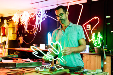 Man Testing Neon Light Sculpture in Workshop