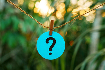 a question mark in blue paper stuck hanging from a string