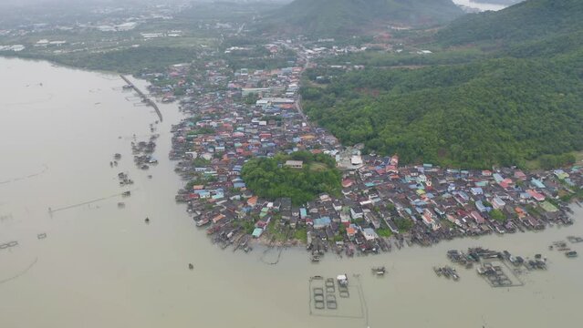 Aerial view of fishing trap net in canel with fisherman urban city village town houses, lake or river. Nature landscape fisheries and fishing tools at Pak Pha, Songkhla, Thailand. Aquaculture farming