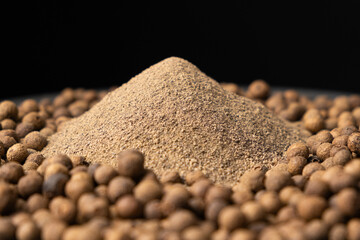 Ground black pepper and peppercorns close-up.