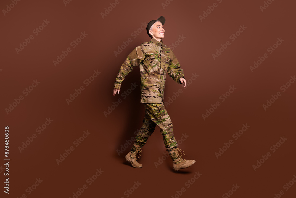 Sticker Full length photo of lovely pensioner lady professional officer walk dressed camouflage army uniform isolated on brown color background