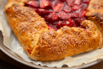 pie with strawberries on a plate, dark background, closeup