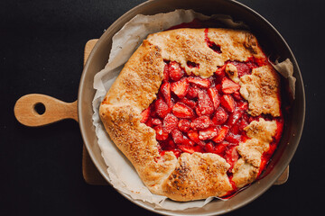 pie with strawberries on a plate, dark background