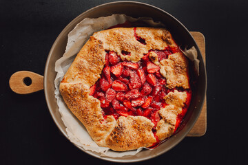 pie with strawberries on a plate, dark background