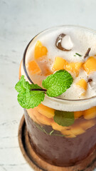Mango iced tea with mint leaves which tastes very refreshing. Iced tea on a white table is very fresh to enjoy in the hot summer