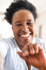 Portrait of happy senior african american woman having video call at home