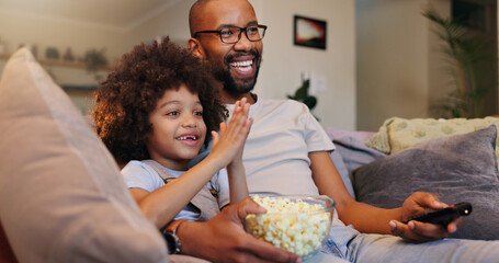 Father, boy and smile with television or popcorn on sofa in living room for movies, cartoon and entertainment. People, parent and happy with kid at home for streaming platform with child development