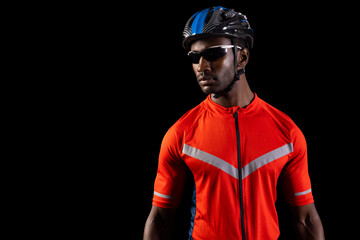 African American cyclist poses confidently on black background, with copy space