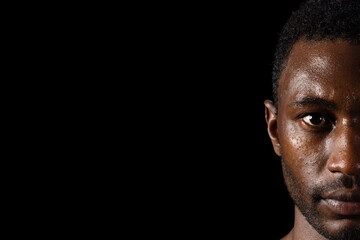 Intense gaze from an African American man, with copy space on a black background