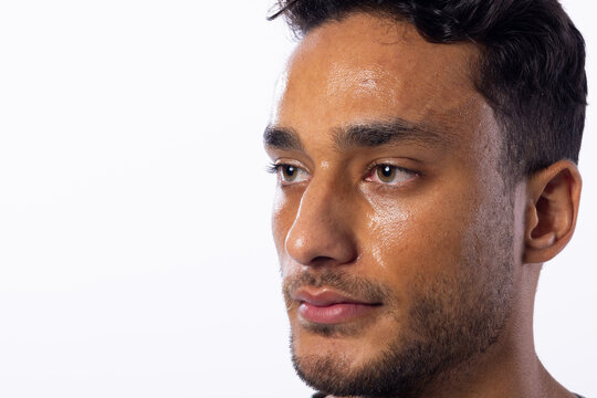 Young biracial man with a contemplative expression, with copy space on a white background - Powered by Adobe