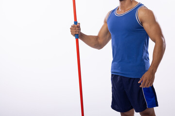Young biracial man holding a javelin on a white background, with copy space