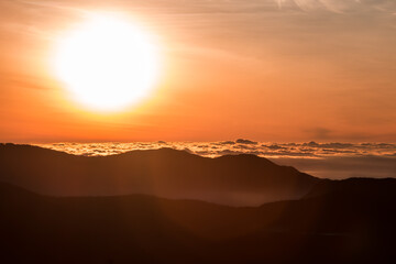 sunset over the mountains and clouds.