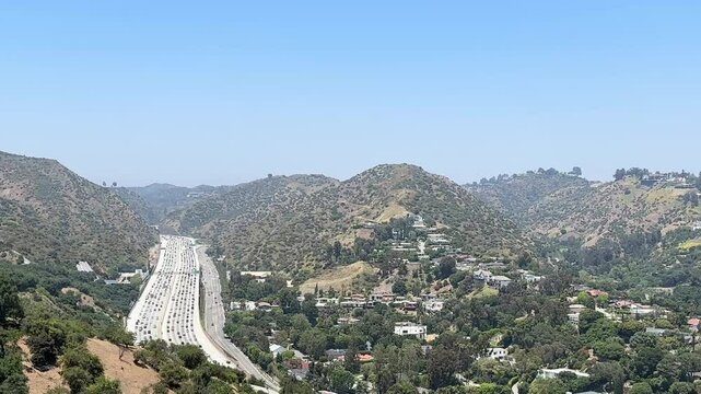Views of the freeway from the Getty Center. The Angels. Busy highway traffic at sunset with view of nearby hills.