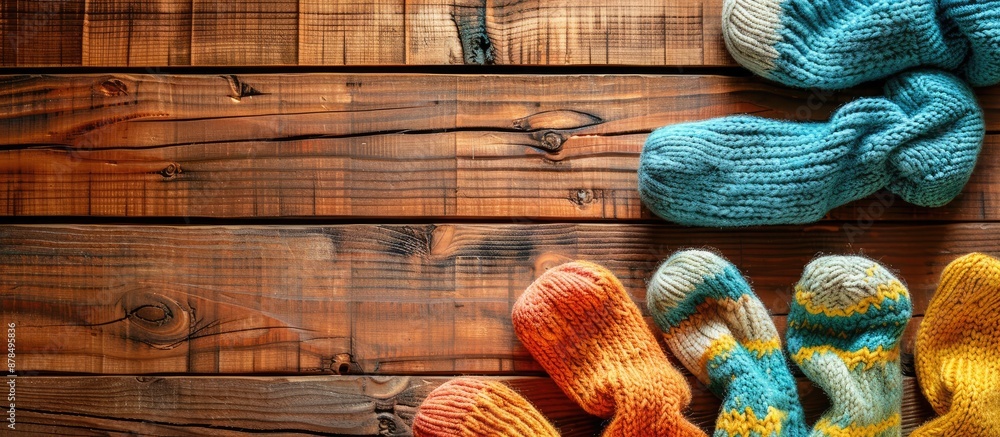 Poster baby socks with a knitted design displayed against a wooden backdrop, offering copy space image.