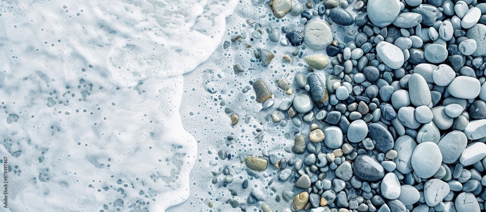 Poster Aerial view of sea pebbles with white copy space image surrounding it.
