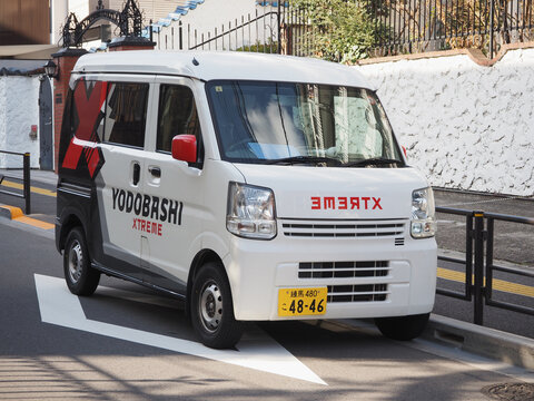 TOKYO, JAPAN - March 7, 2024: A Yodobashi xtreme delivery van by a 1960s apartment building in in Tokyo's Yayoi area in Bunkyo Ward.