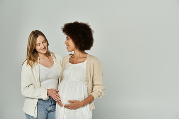 A pregnant African American woman and her partner, a lesbian couple, stand side by side with love and anticipation.