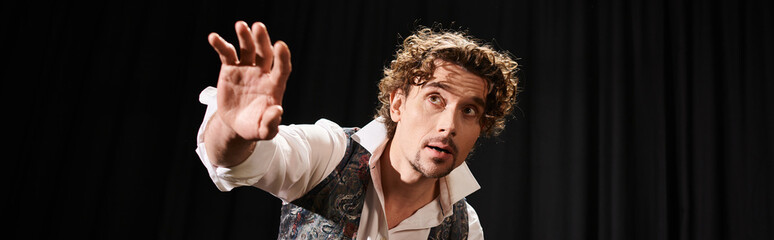 A man with curly hair pulls a confident face.