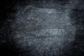 A black and white photo of a wall with a lot of cracks and holes. The wall appears to be old and worn down