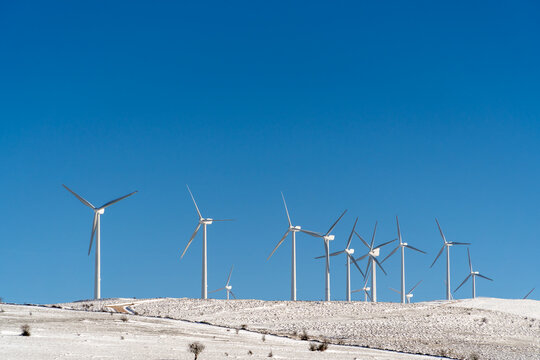 Wind turbines on a snowy hillside promoting green energy