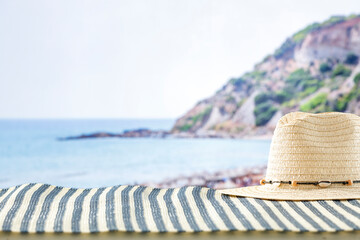 Beach accessories on summer beach mat on a tropical sandy beach. Seascape background. Copy space...