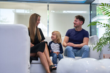 mother and mother look at each other while their son is looking grim, they are waiting in the dentist's waiting room.