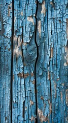 Old cracked blue paint is peeling from a wood surface, showing knots and grain in the wood underneath. The texture of the old paint and wood creates a rustic and vintage feel