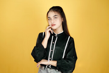 Smiling young asian woman looking up empty space deep thinking creative