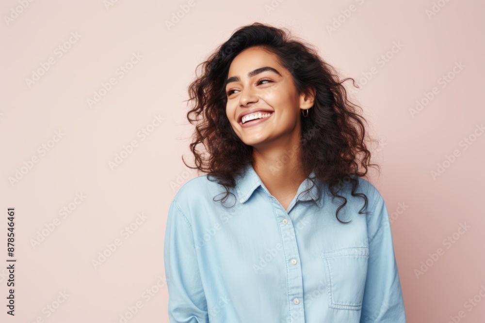 Wall mural portrait of a joyful indian woman in her 20s sporting a versatile denim shirt isolated on pastel or 