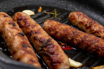 Grilled sausages on grill frying pan.