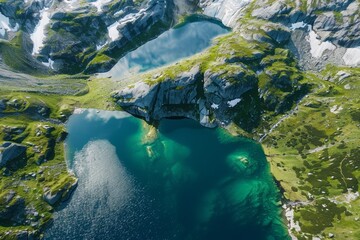 Aerial view of alpine lakes surrounded by rocky mountains and green meadows with clear turquoise water