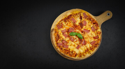 Round baked pizza on a wooden cutting board