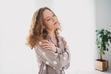 Photo of pretty young girl closed eyes cuddle shoulders wear pajama bright interior bedroom...