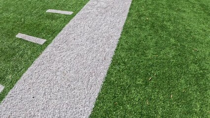 Football Field Turf in Motion. Slow motion views moving across a green turf football or soccer field with yard line markings. Overhead view.