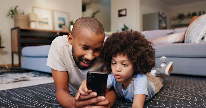 Happy dad, child and floor with phone for streaming, entertainment or social media at home. Father, son or little boy lying on living room carpet on mobile smartphone for online browsing or games