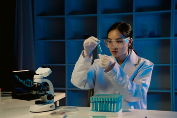 In a laboratory, a scientist in a lab coat and safety glasses is meticulously using a pipette to...