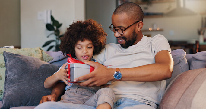 Happy dad, son and gift with box for birthday surprise, childhood or bonding on sofa at home. Father giving child, kid or little boy present, parcel or package with ribbon for appreciation at house