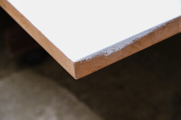 Painted wooden table corner into white color of paint. Renovation concept