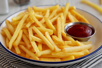 Homemade American French Fries with Ketchup on a Plate, side view. Close-up.