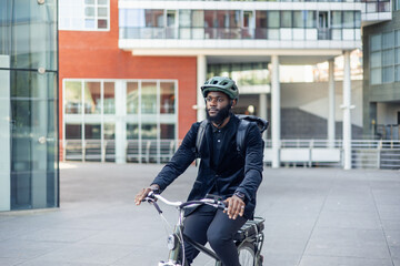 Sustainable Urban Commute: black African American Businessman on Electric Bike