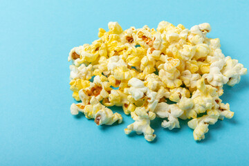 Salted popcorn on a blue background. Cinema and entertainment concept. Movie night with popcorn....