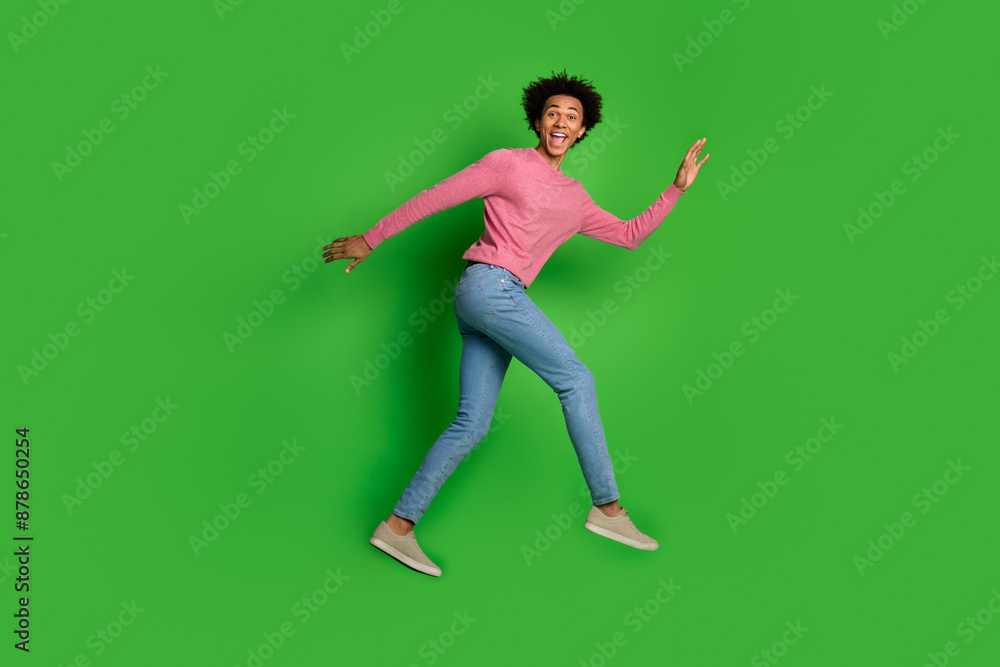 Sticker Full length photo of handsome good mood guy wear pink sweater jumping high walking emtpy space isolated green color background