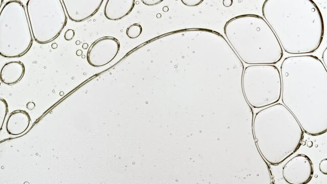 Transparent cosmetic gel fluid with molecule bubbles oil distribution. Bubble cluster, cells under a microscope. Macro Shot of Natural Organic Cosmetics, Medicine. Production Close-up. Slow Motion. 4k