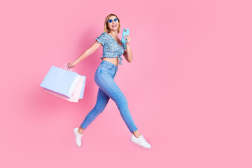 Full length photo of girly woman wear blue blouse jumping high read device rising bargains empty space isolated pink color background