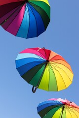 Colorful umbrellas hanging in the air as urban decoration representing LGBTQ pride parade