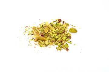 Scattered pistachio nut pieces isolated. Break chopped pistachios pile, fried baked diced pistache on white background 