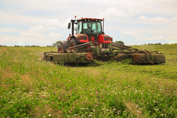 tractor, feed, harvesting, hay. A tractor mows the grass. haymaking, fodder harvesting. Copy space