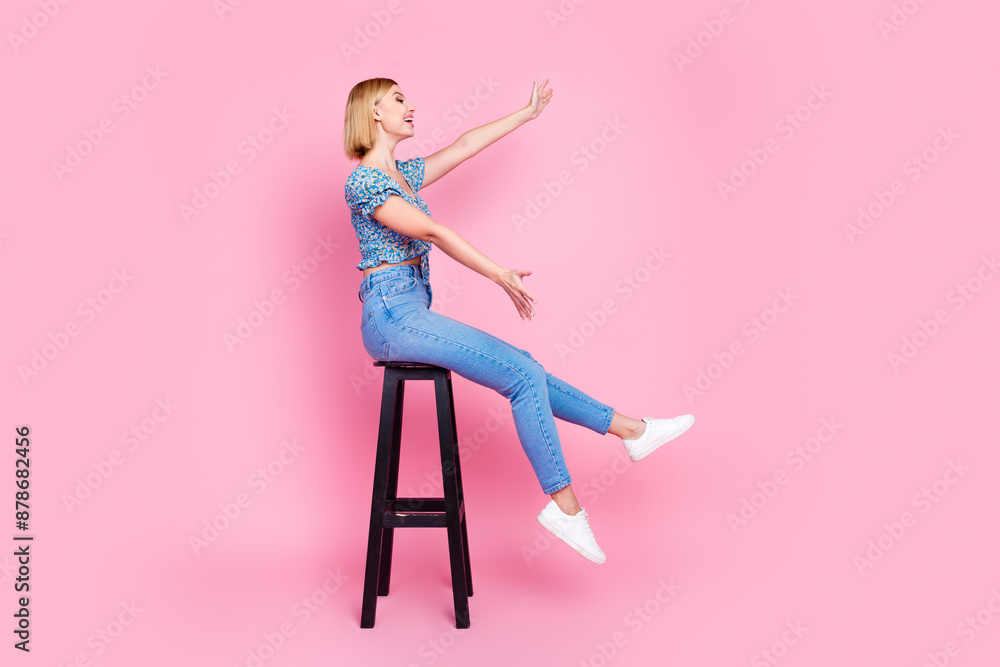 Sticker full length photo of charming excited woman wear blue blouse sitting stool catching empty space isol